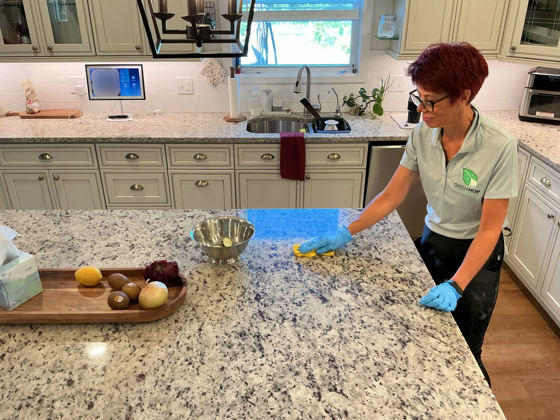 A Green Mop cleaner wiping a kitchen worktop