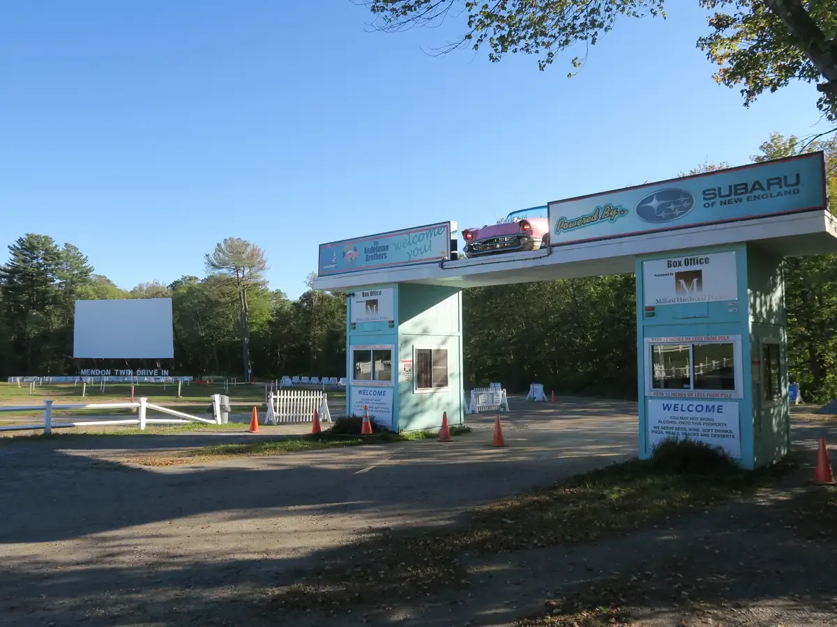 The retro entrance arch of the Mendon Twin Drive-In with the screen standing behind it